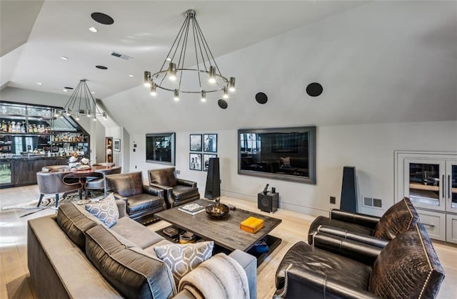 living area featuring vaulted ceiling, wood finished floors, visible vents, and wet bar