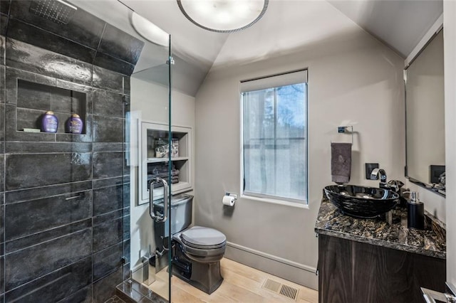 bathroom featuring visible vents, lofted ceiling, toilet, wood finished floors, and vanity