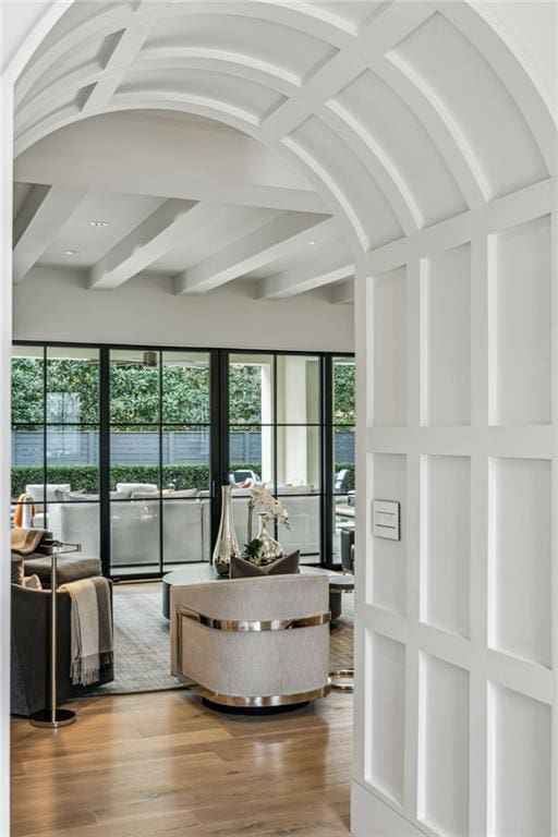 living room featuring beam ceiling and wood finished floors