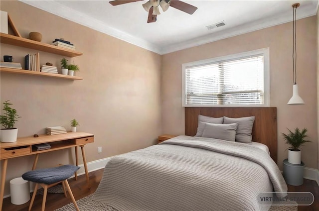 bedroom featuring dark wood-type flooring, ceiling fan, baseboards, visible vents, and crown molding