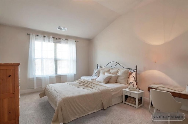 carpeted bedroom with visible vents and vaulted ceiling