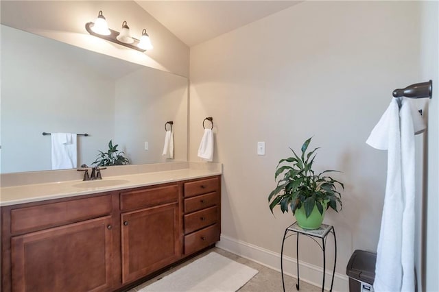 bathroom with vanity, tile patterned flooring, and baseboards