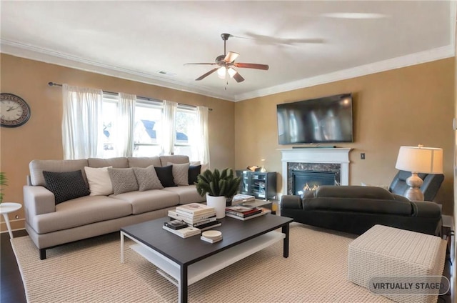 living room featuring a fireplace, ornamental molding, and ceiling fan