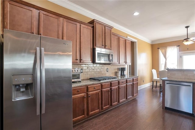 kitchen featuring ornamental molding, appliances with stainless steel finishes, light stone counters, and decorative backsplash