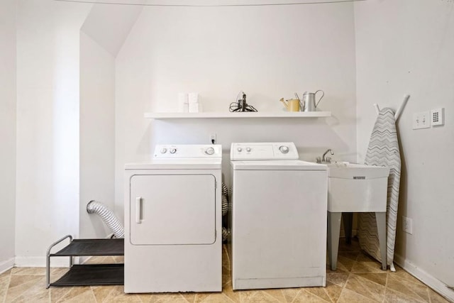 clothes washing area featuring laundry area, separate washer and dryer, and baseboards