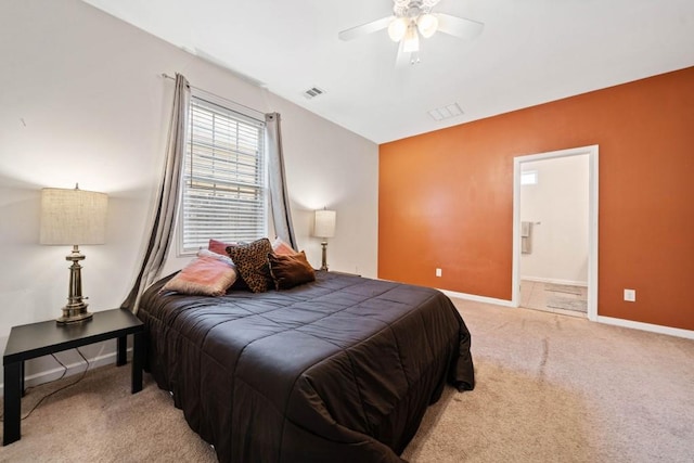 bedroom with a ceiling fan, baseboards, visible vents, ensuite bathroom, and light carpet