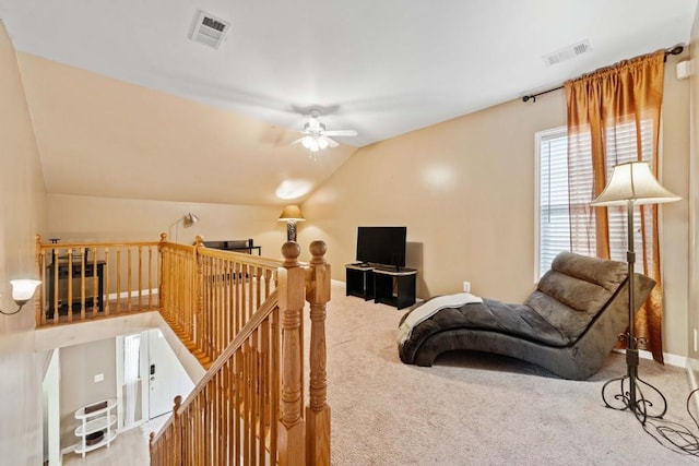 living area featuring visible vents, an upstairs landing, lofted ceiling, and carpet floors