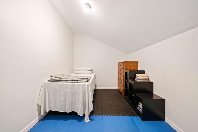 bedroom with carpet flooring, baseboards, and vaulted ceiling