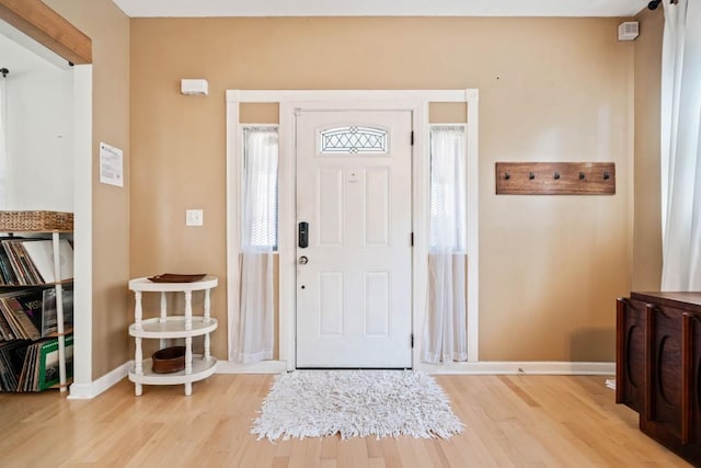 entryway featuring baseboards and light wood-style floors