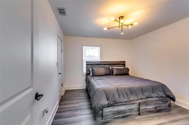 bedroom featuring a chandelier and dark hardwood / wood-style floors