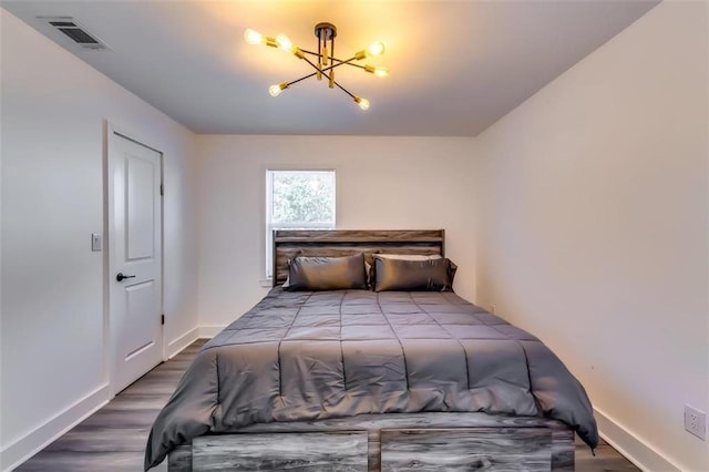 bedroom featuring hardwood / wood-style flooring and an inviting chandelier