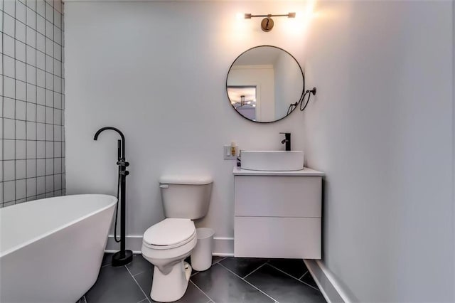 bathroom featuring toilet, vanity, tile patterned floors, and a bath