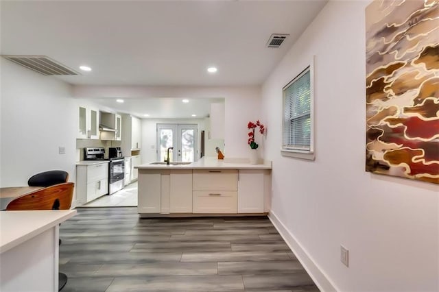 kitchen featuring dark hardwood / wood-style flooring, white cabinetry, stainless steel range with electric stovetop, french doors, and sink