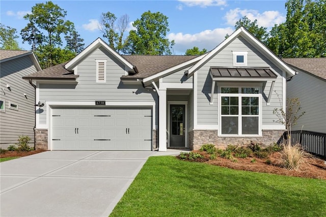 craftsman inspired home with concrete driveway, a garage, a front yard, and stone siding
