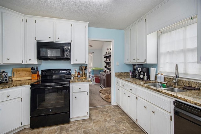 kitchen featuring stone counters, white cabinetry, sink, and black appliances