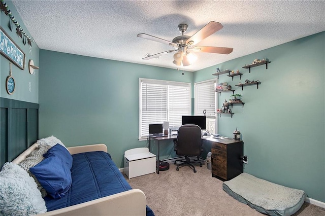 carpeted office space with a textured ceiling and ceiling fan