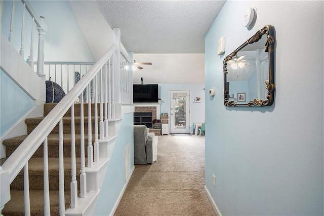 hall with light carpet and a textured ceiling