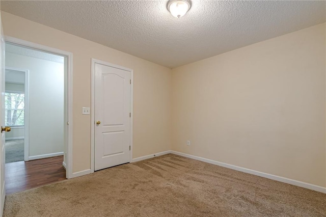 carpeted spare room with a textured ceiling