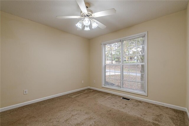 carpeted spare room featuring ceiling fan