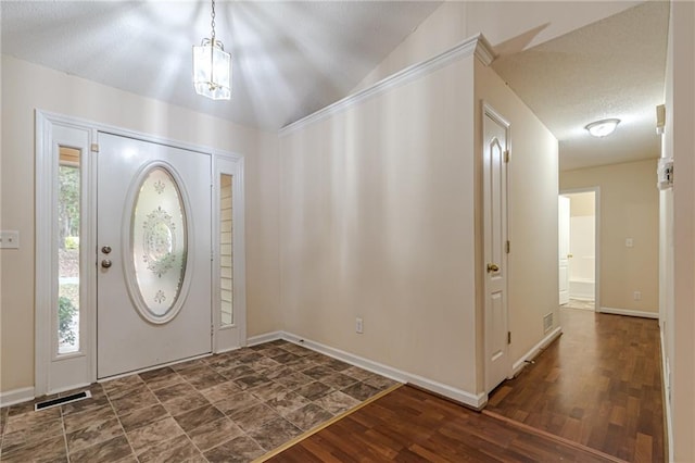 entryway featuring vaulted ceiling, a textured ceiling, and dark hardwood / wood-style flooring