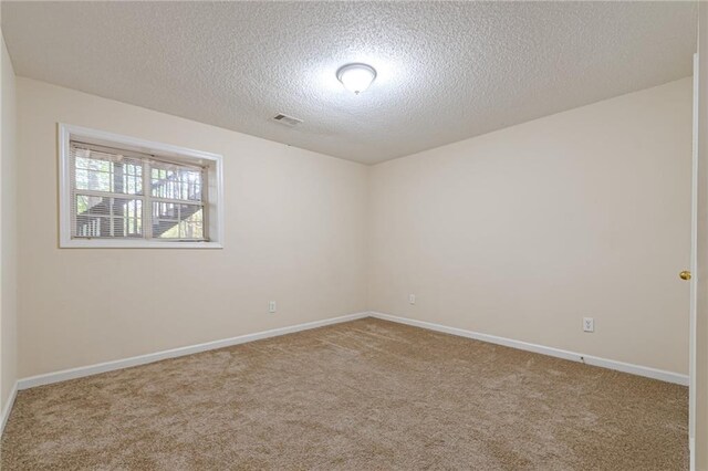 carpeted empty room featuring a textured ceiling