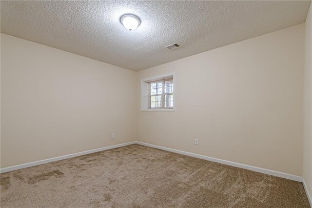 unfurnished room featuring a textured ceiling and carpet flooring