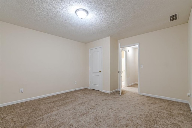 carpeted spare room with a textured ceiling