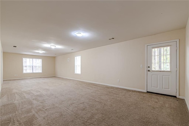 carpeted empty room featuring plenty of natural light