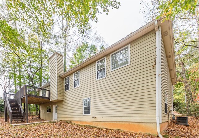 rear view of property with central air condition unit and a wooden deck