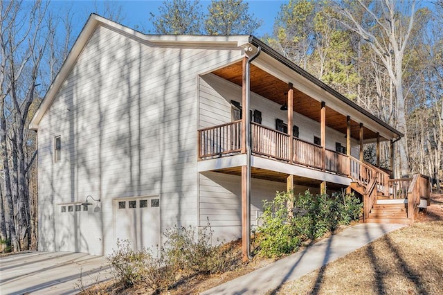 view of property exterior featuring driveway, an attached garage, and a balcony