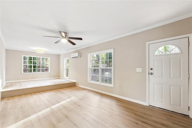 entryway featuring ceiling fan, crown molding, light hardwood / wood-style flooring, and a wall mounted air conditioner