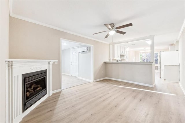 unfurnished living room featuring ceiling fan, ornamental molding, light hardwood / wood-style floors, and an AC wall unit