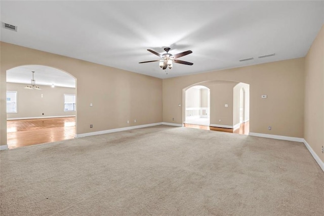 4499 Bellemeade Dr, Douglasville, GA 30135 - spare room featuring visible vents, light carpet, arched walkways, baseboards, and ceiling fan