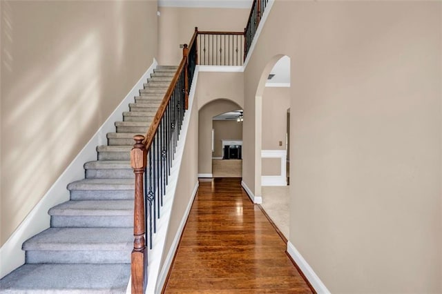 4499 Bellemeade Dr, Douglasville, GA 30135 - stairs with wood finished floors, ceiling fan, arched walkways, baseboards, and a high ceiling