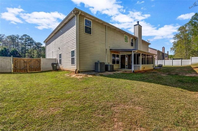 4499 Bellemeade Dr, Douglasville, GA 30135 - back of property featuring a sunroom, a fenced backyard, a chimney, and a lawn