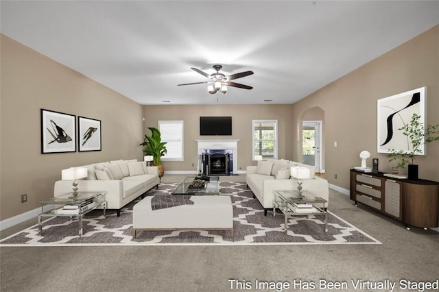 4499 Bellemeade Dr, Douglasville, GA 30135 - living area featuring a ceiling fan, arched walkways, baseboards, a fireplace, and carpet flooring