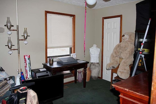 carpeted home office with ceiling fan and a textured ceiling