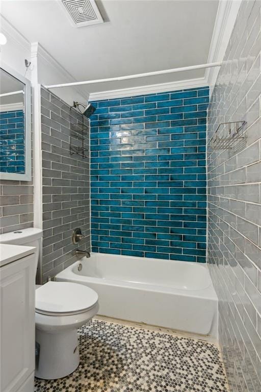 full bathroom with crown molding, tile walls, tiled shower / bath combo, vanity, and toilet