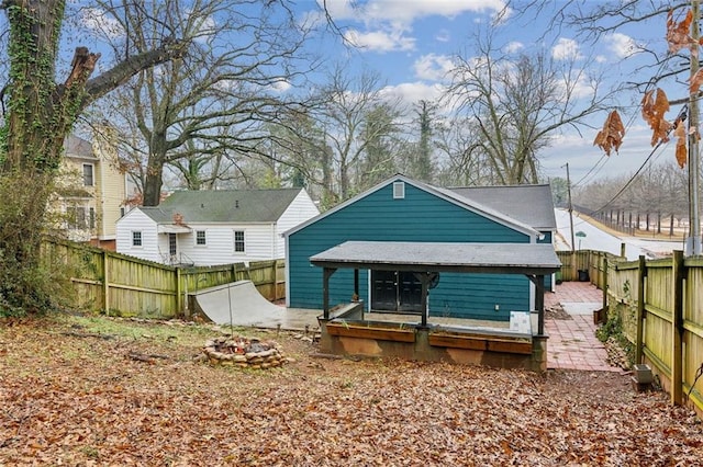 rear view of property with a fire pit