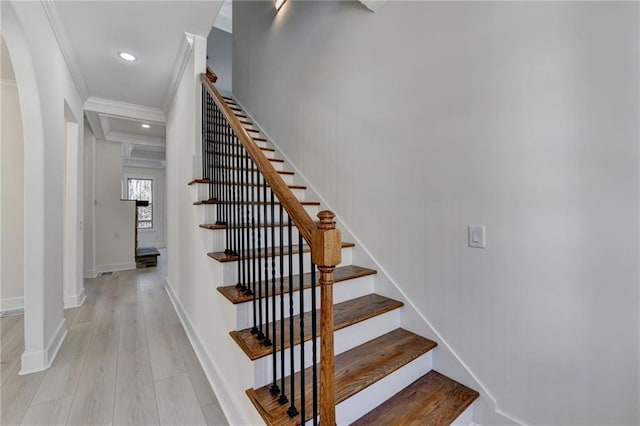 stairs with hardwood / wood-style flooring and crown molding