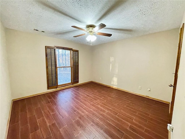 unfurnished room with a ceiling fan, a textured ceiling, visible vents, baseboards, and dark wood-style floors