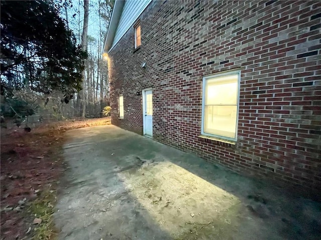 view of home's exterior featuring brick siding and a patio area