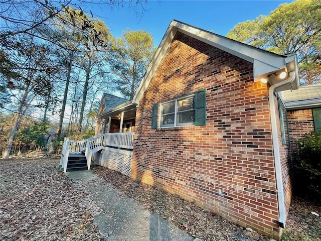 view of home's exterior featuring brick siding and covered porch