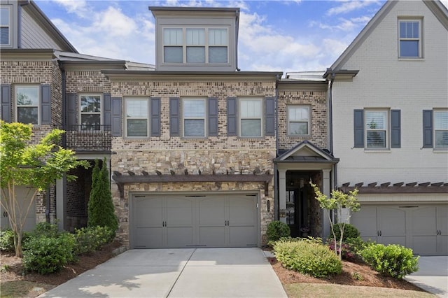 townhome / multi-family property with an attached garage, driveway, and brick siding