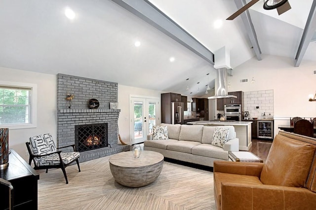 living room featuring ceiling fan, beverage cooler, a brick fireplace, and vaulted ceiling with beams