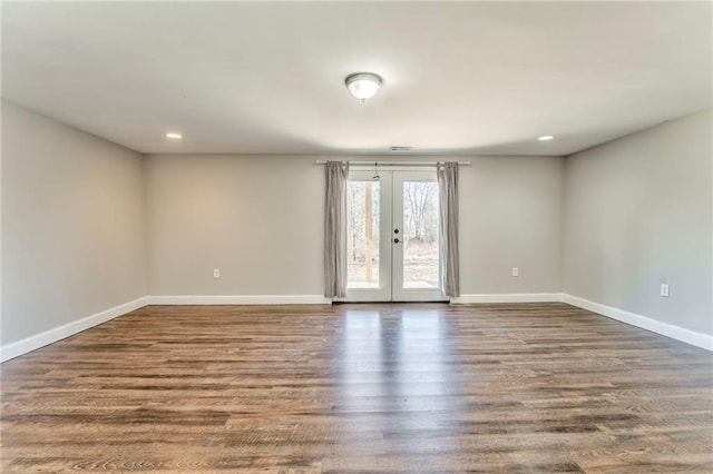 spare room featuring dark hardwood / wood-style flooring and french doors