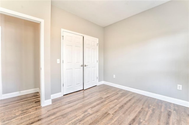 unfurnished bedroom featuring light hardwood / wood-style floors and a closet