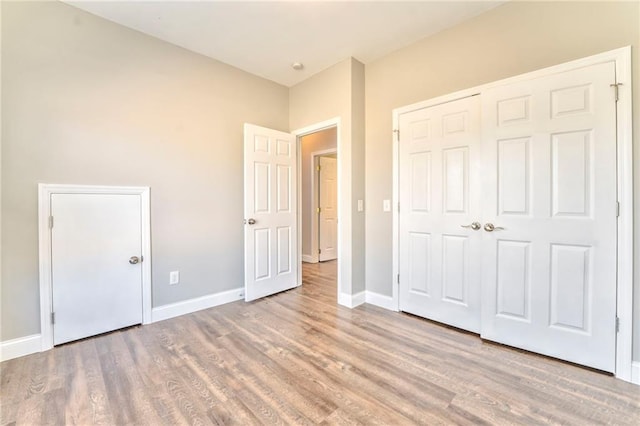 unfurnished bedroom featuring light hardwood / wood-style floors and a closet