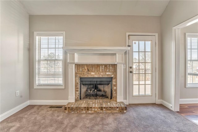 unfurnished living room with carpet floors and a fireplace