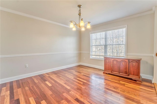 spare room featuring ornamental molding, a chandelier, and light hardwood / wood-style flooring